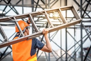 Construction fall concept. Young Asian maintenance worker carrying aluminium ladder